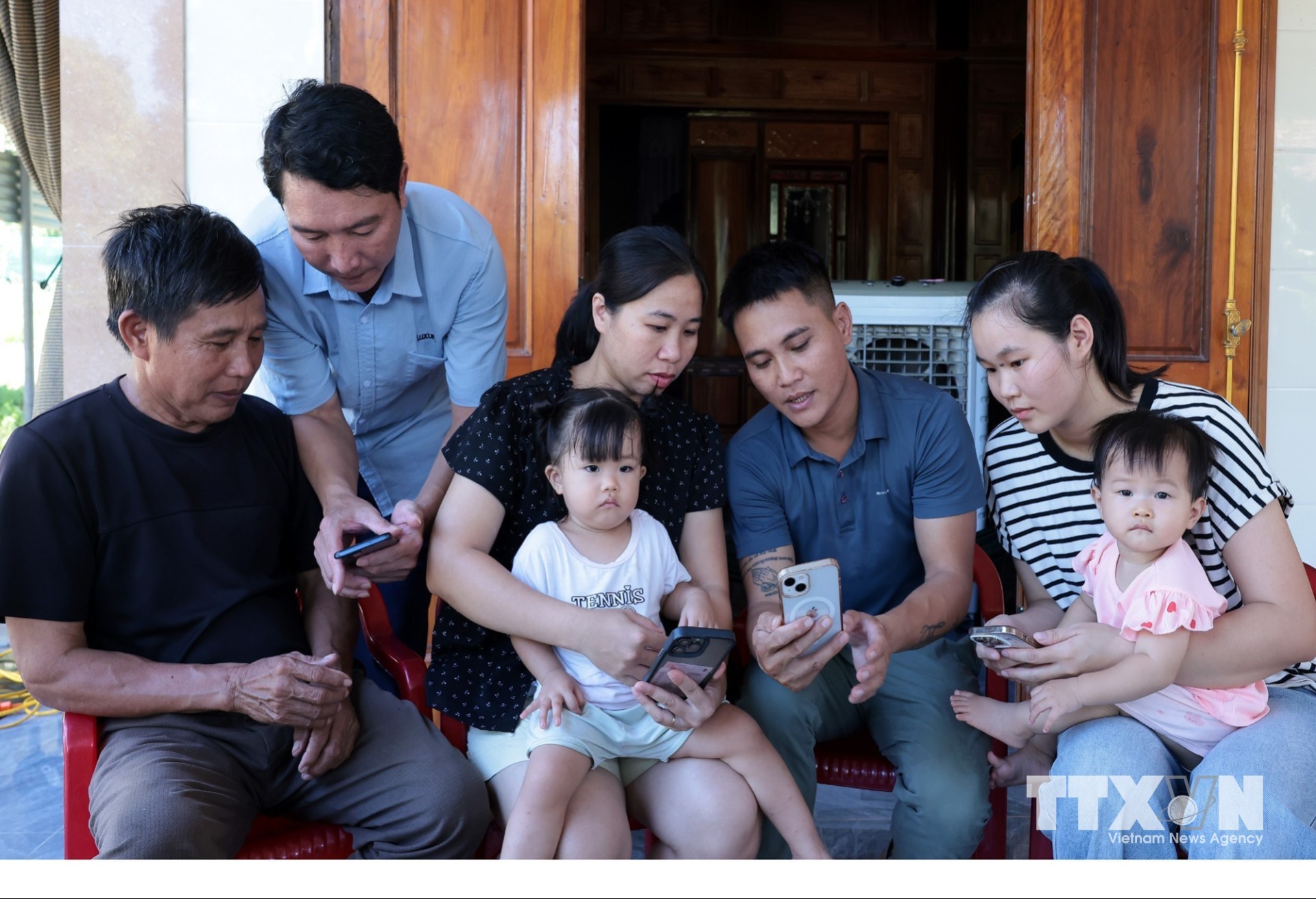 Trợ giúp người dân cài đặt, khai thác, sử dụng thông tin trên ứng dụng Quangtri - S và các ứng dụng khác. (Ảnh: Trần Việt/TTXVN)